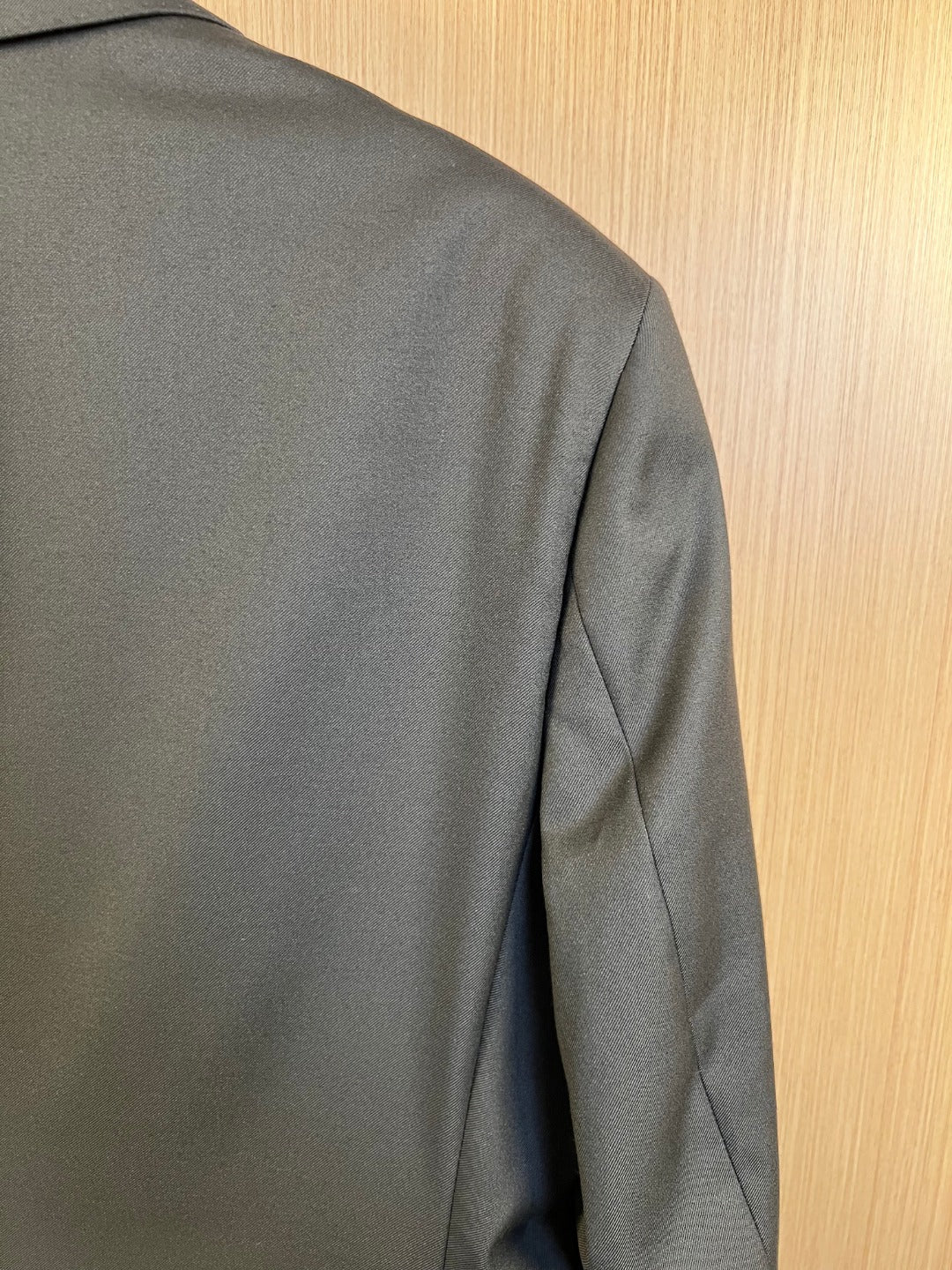 Dark long coat back panel with shoulder seam and side seam detail