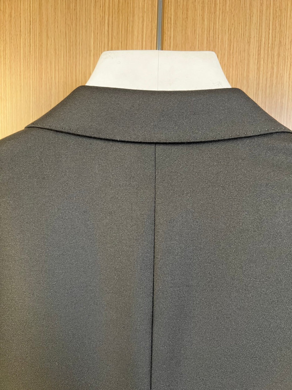 Dark long coat with structured collar and central back seam