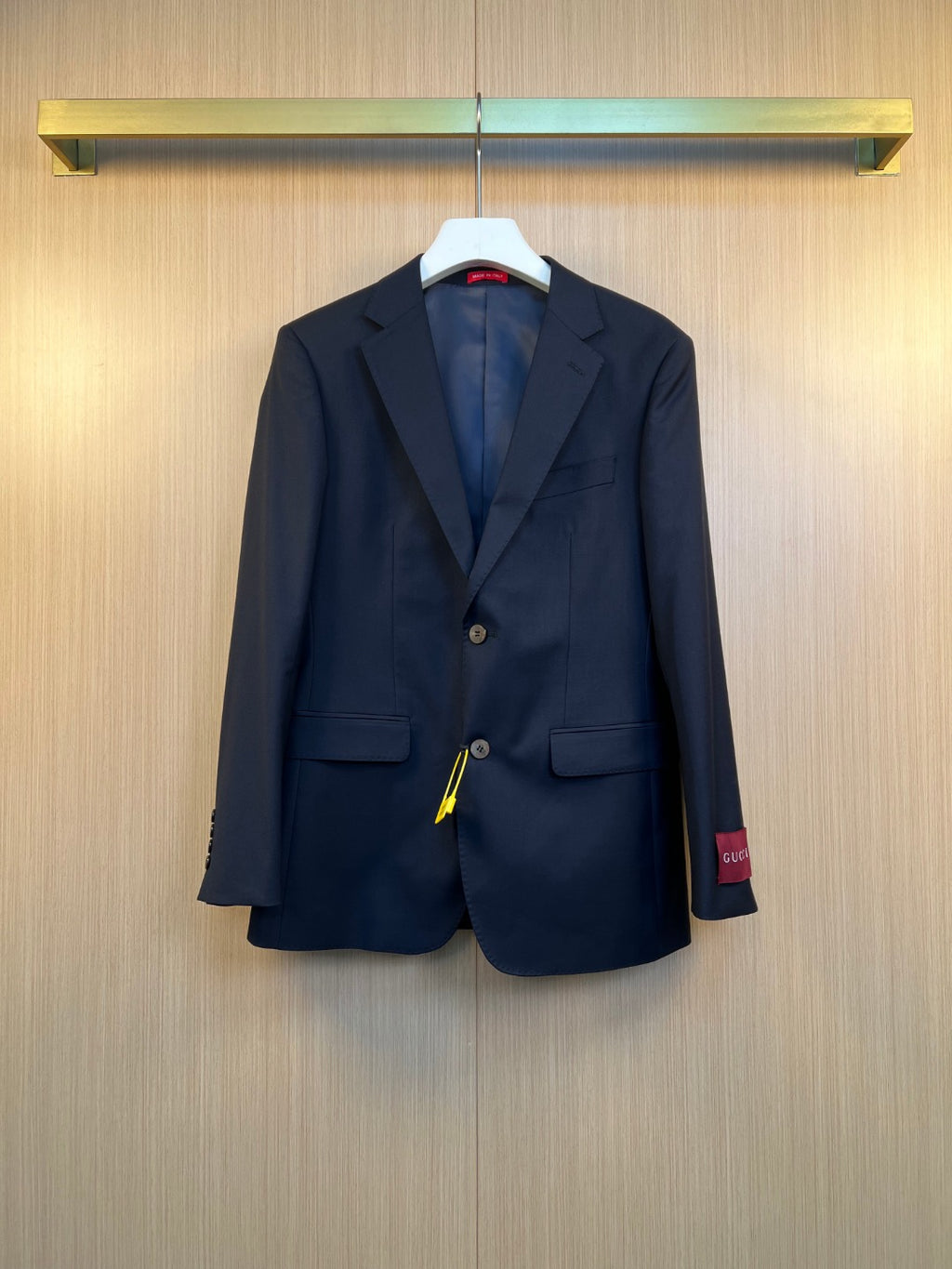 Navy suit jacket with notched lapels, flap pockets, and button front