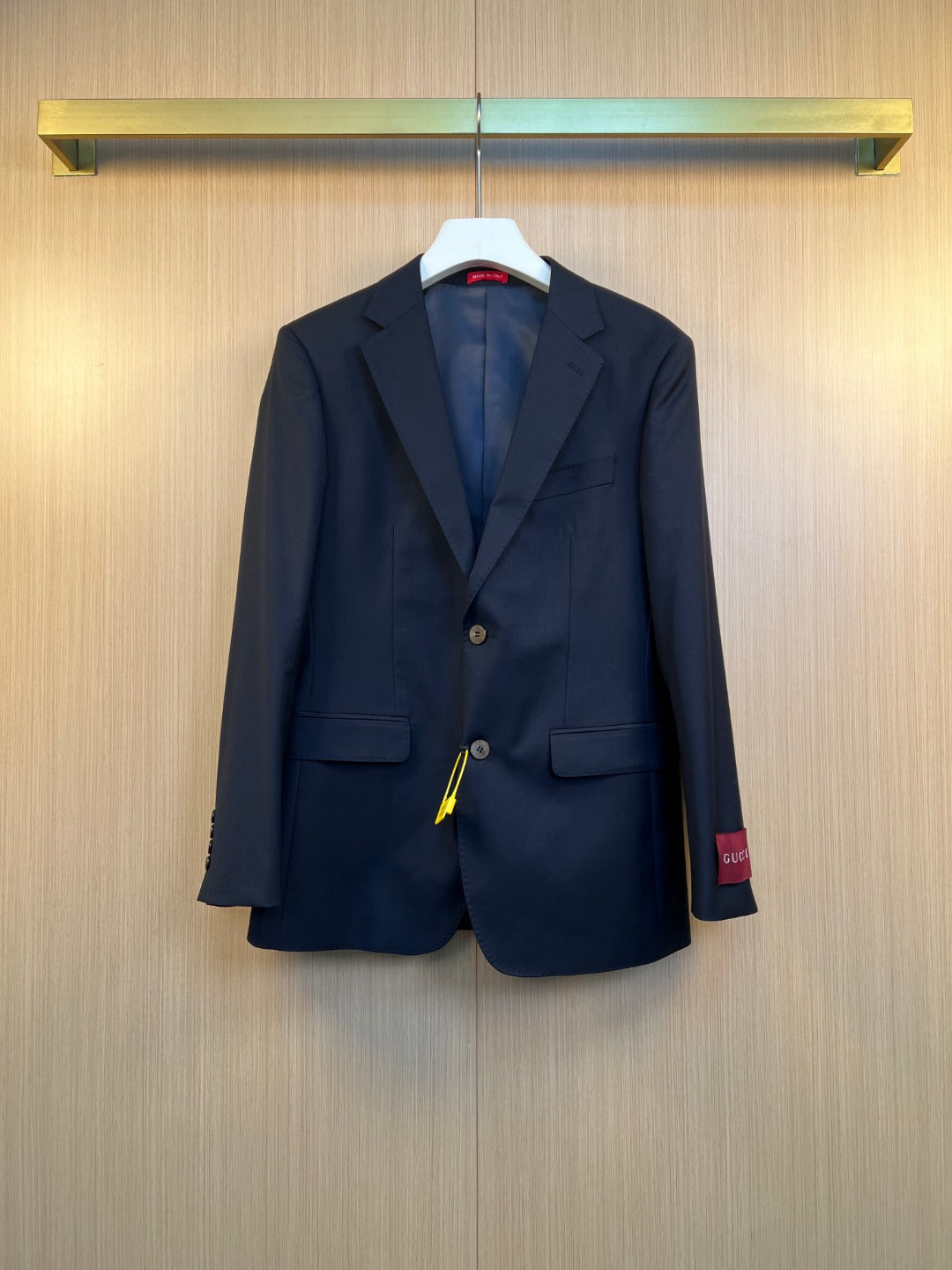 Navy suit jacket with notched lapels, flap pockets, and button front