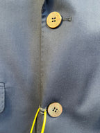 Navy blazer fabric detail with gold-tone buttons and stitched seam
