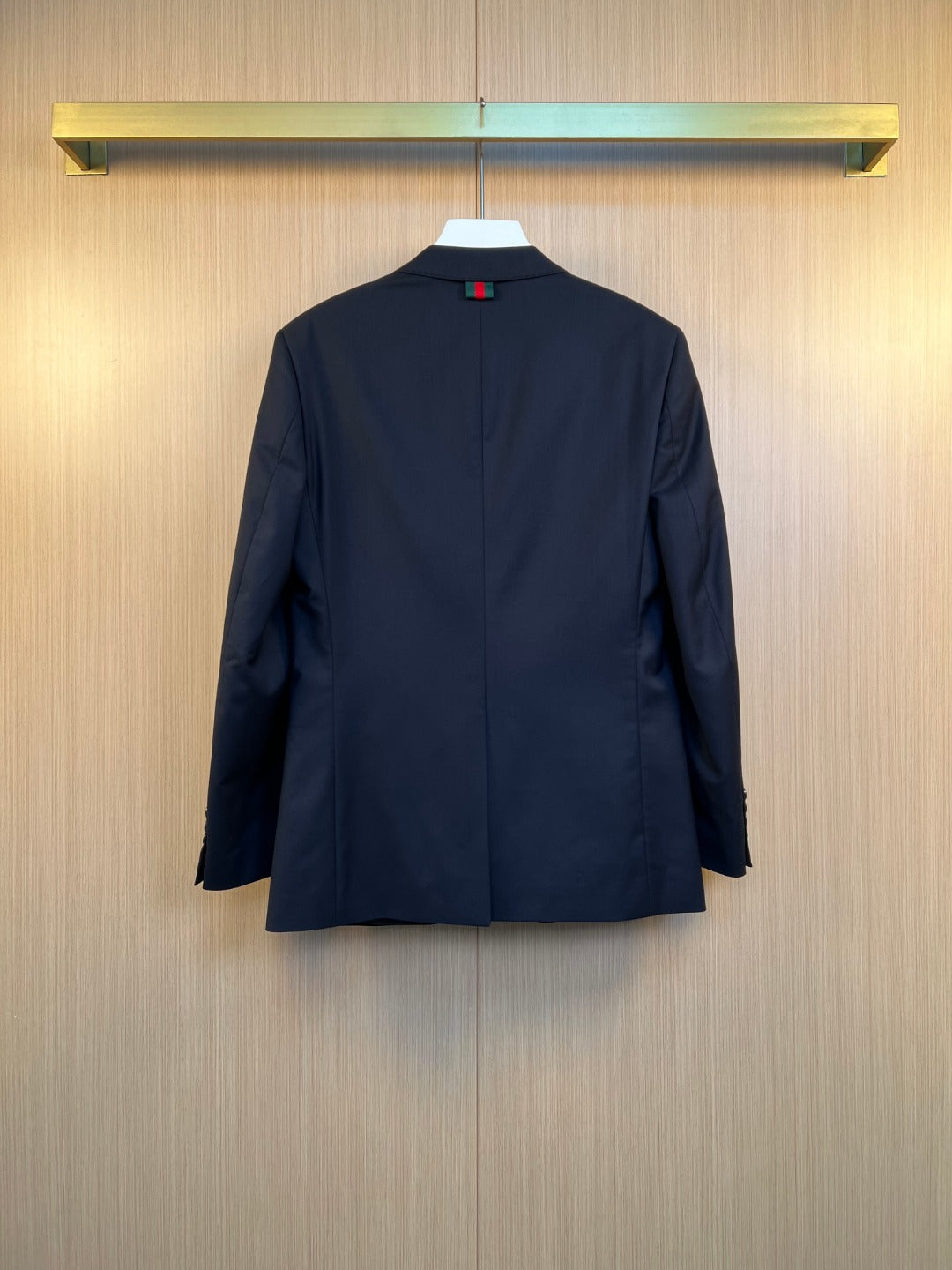 Navy suit jacket back view with center seam and buttoned neckline
