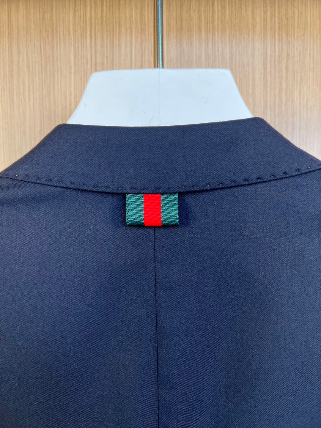 Navy suit jacket back collar with green and red web detail