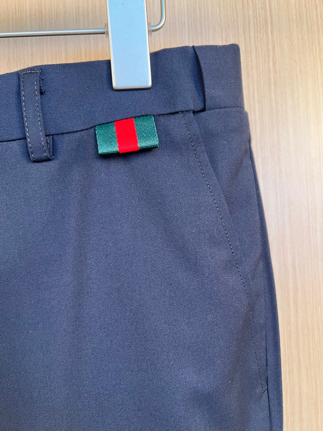 Dark navy pants waistband and fly detail with green-red stripe designer tag