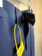 Dark navy pants side view with pocket opening and hanging accessory tags