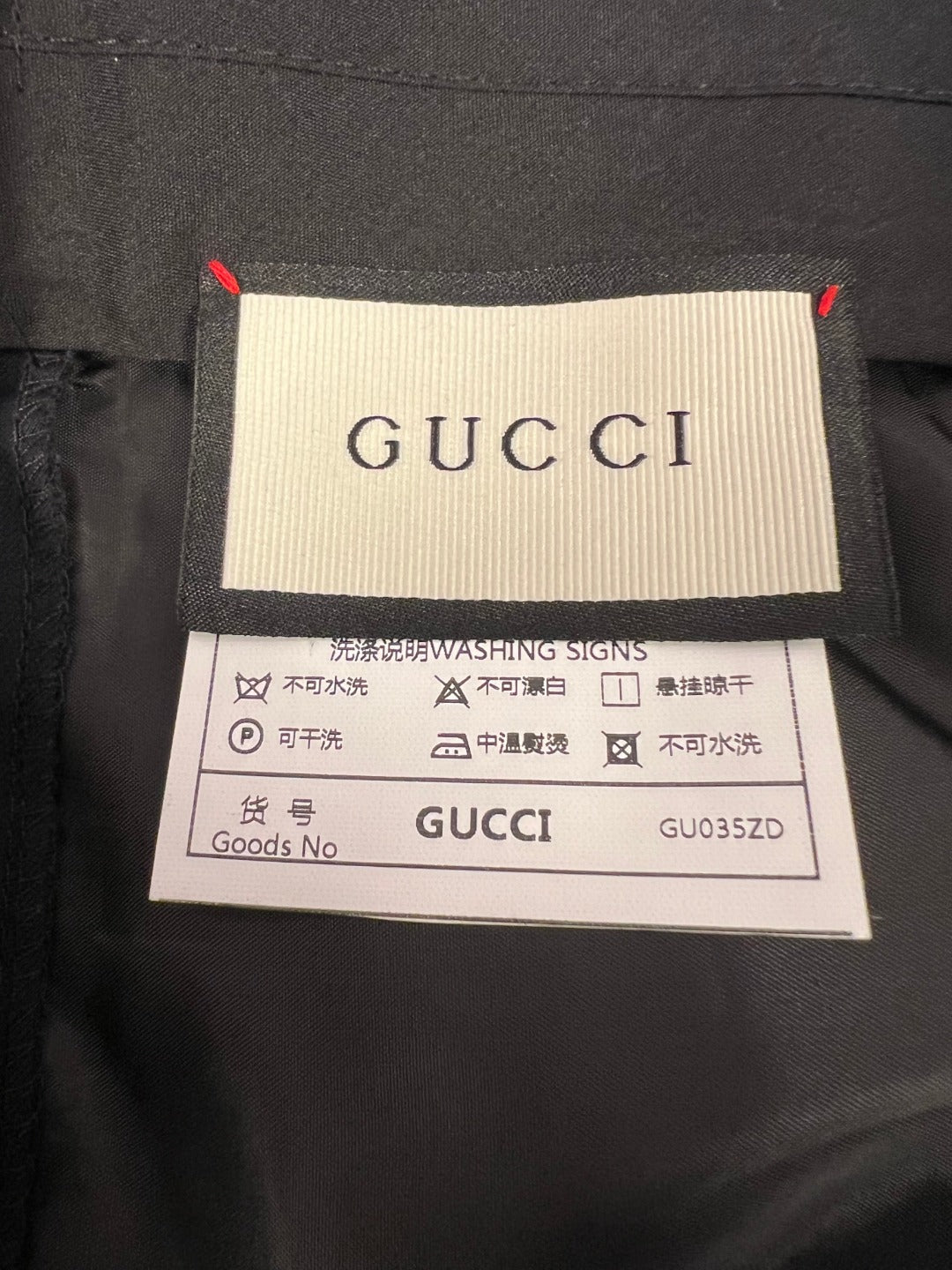 Gucci care label on dark fabric with washing instructions