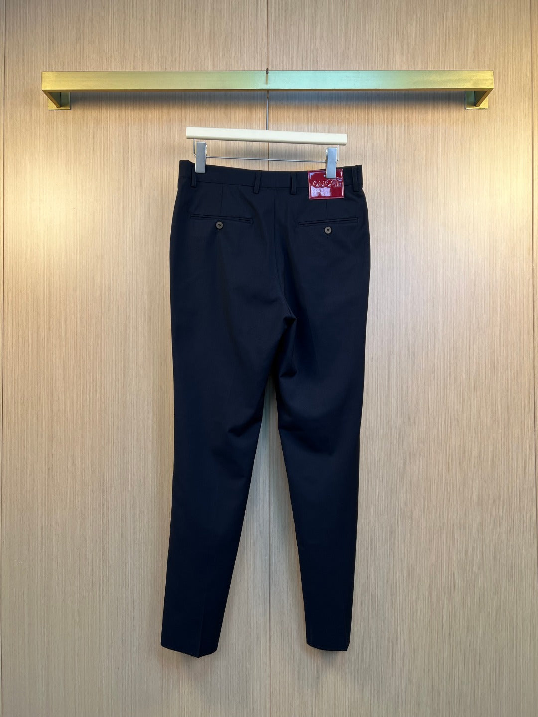 Dark navy pants on hanger with belt loops and front button closure