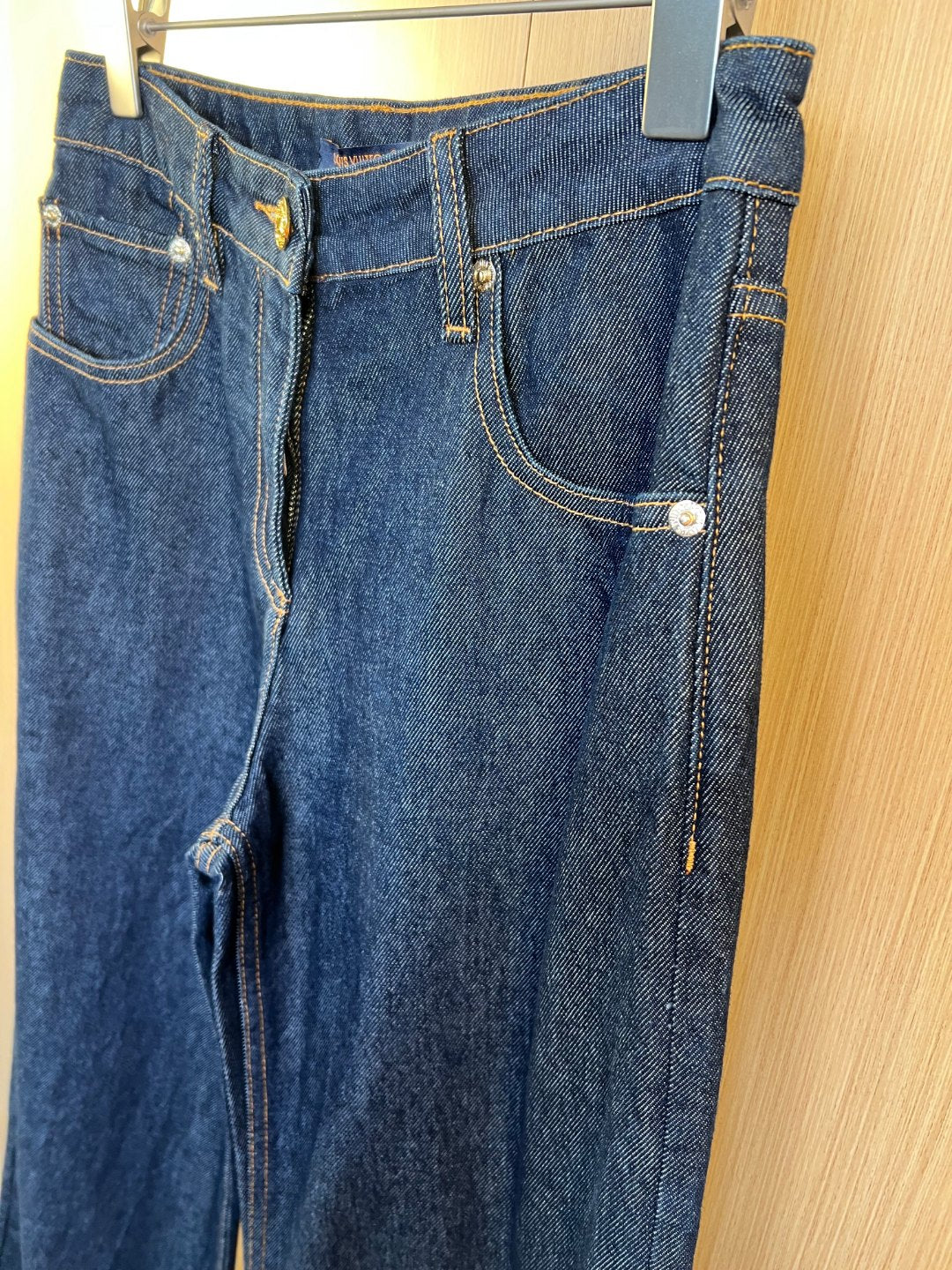 Denim pants with back pockets, button fly, and contrast yellow topstitching
