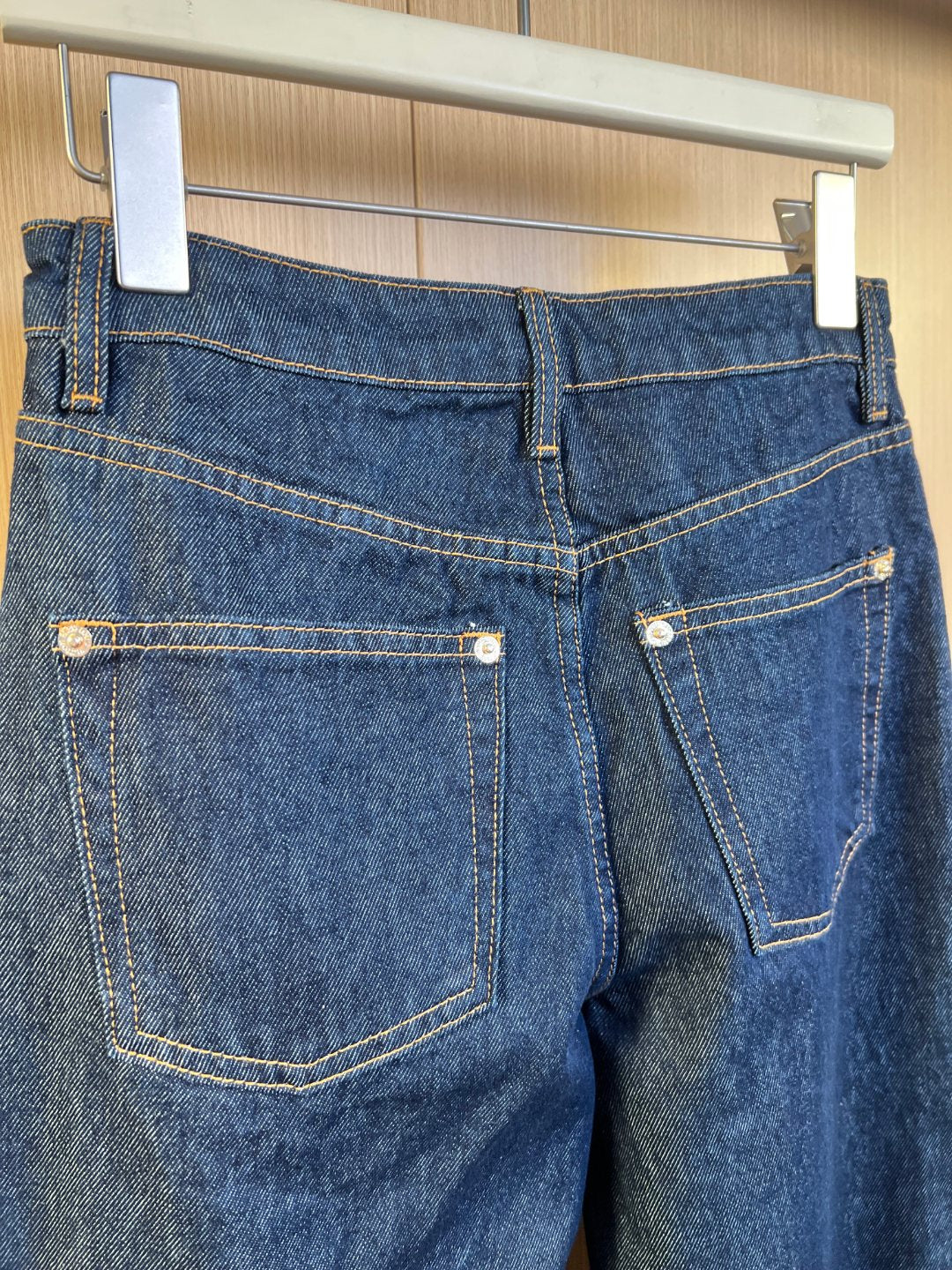 Denim pants back view with two pockets and contrast yellow topstitching