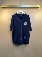 Navy knit polo shirt with button placket and embroidered crest on chest