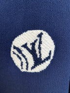 Embroidered crest patch on navy knit polo shirt