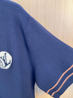 Navy knit polo shirt sleeve with embroidered crest logo