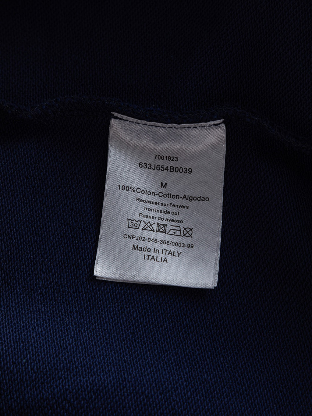 Dior long garment care label on dark fabric, 100% cotton