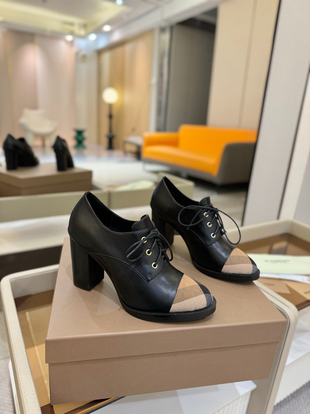 Pair of black lace-up high-heel shoes with beige check toe panel