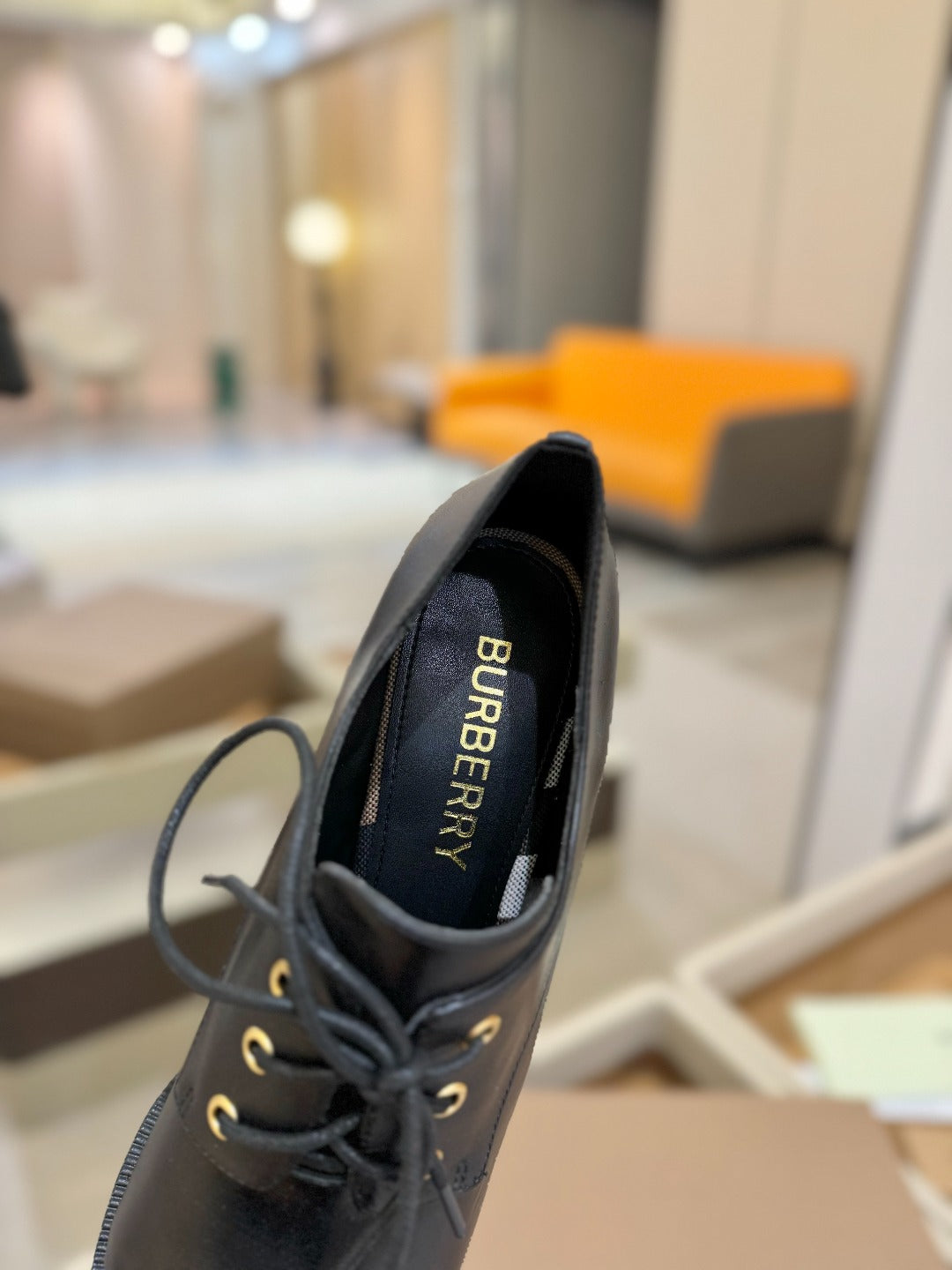 Black Burberry lace-up shoe with "BURBERRY" text on inner lining