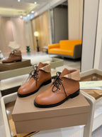 Burberry lace-up leather shoes pair on box; tan uppers, beige collar, black sole.