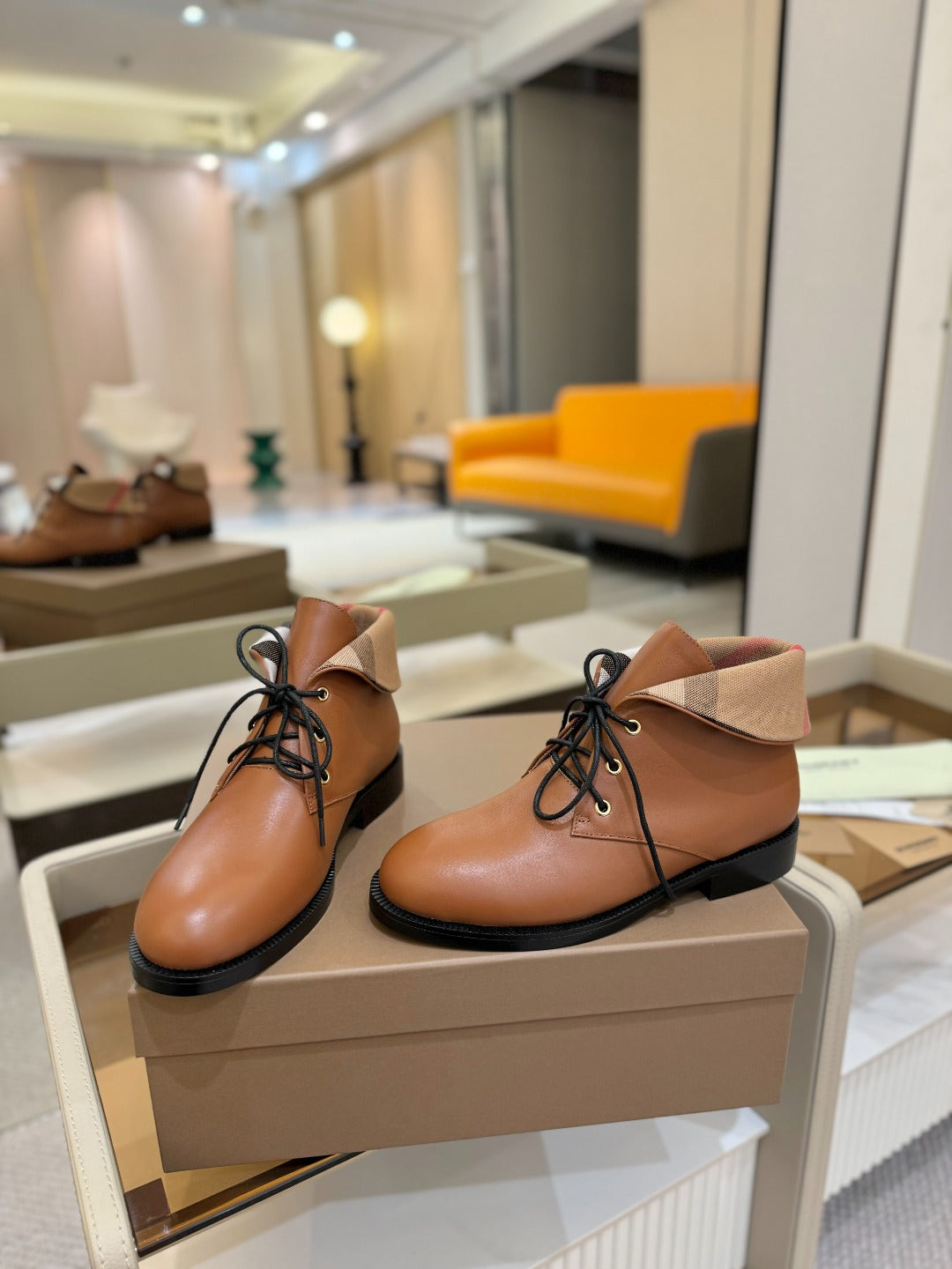 Burberry lace-up leather shoes, tan uppers with beige collar and black sole, front view.