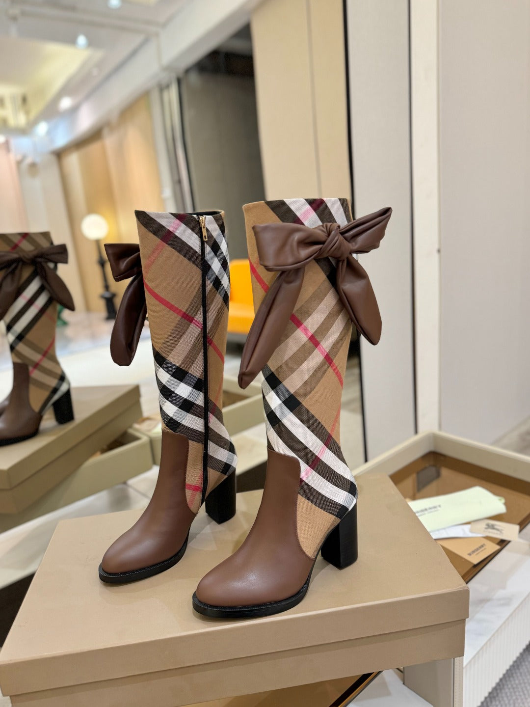 Brown heeled boots with Burberry check shaft and front bow