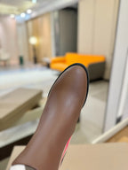 Brown boot shaft with stitched edge and dark heel, side close-up