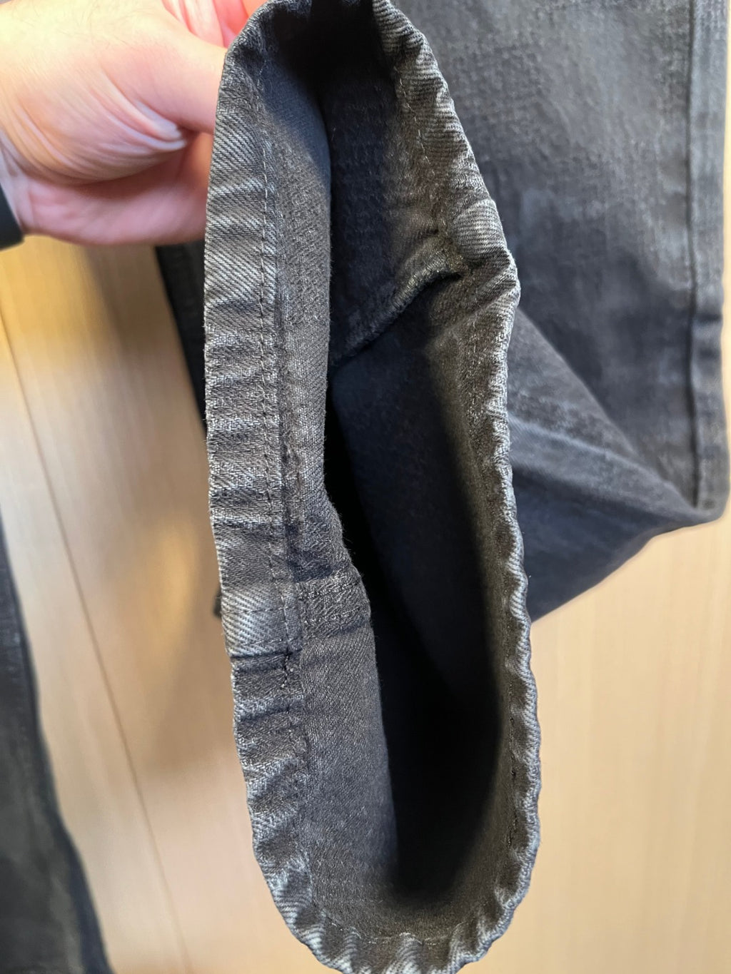 Dark denim jeans back pocket view with visible inner seam