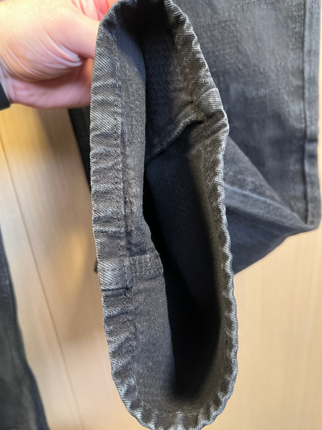 Dark denim jeans back pocket view with visible inner seam
