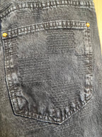 Dark denim jeans close-up of back yoke stitching and gold button