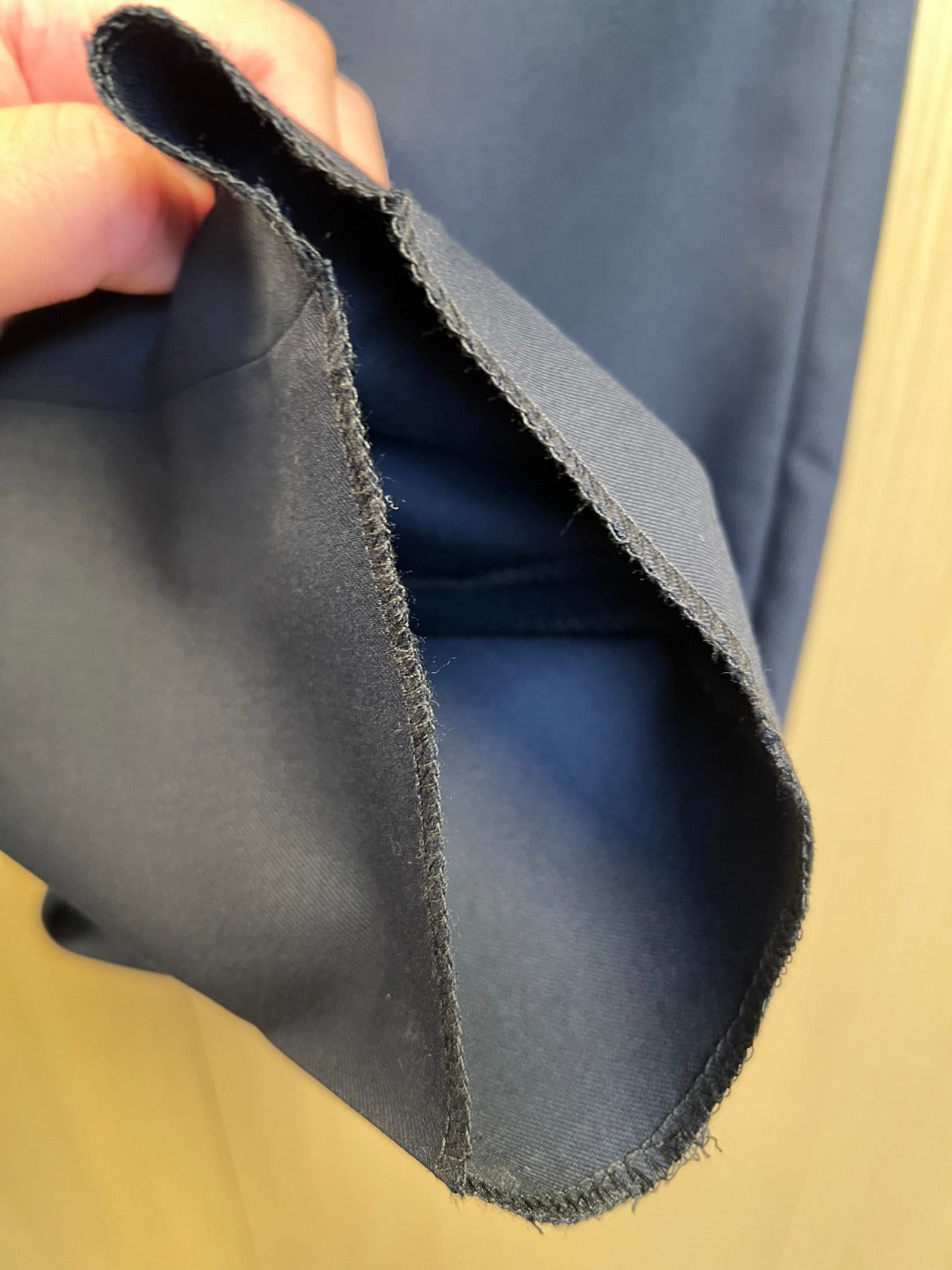 Navy pants inner hem with stitched lining and visible seam.