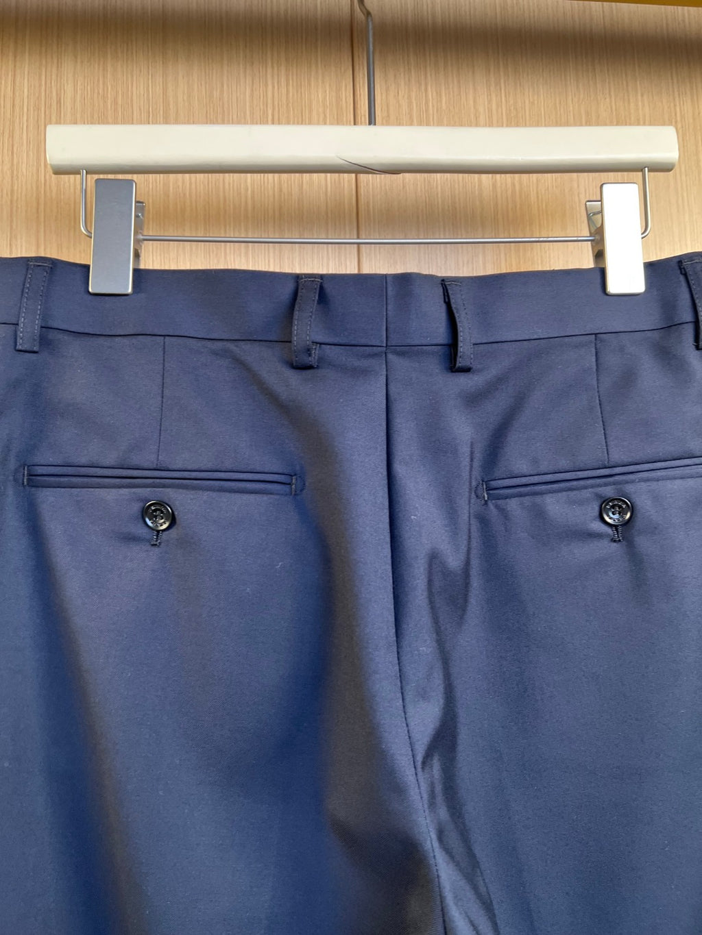 Navy pants front with two side pockets and button closure.