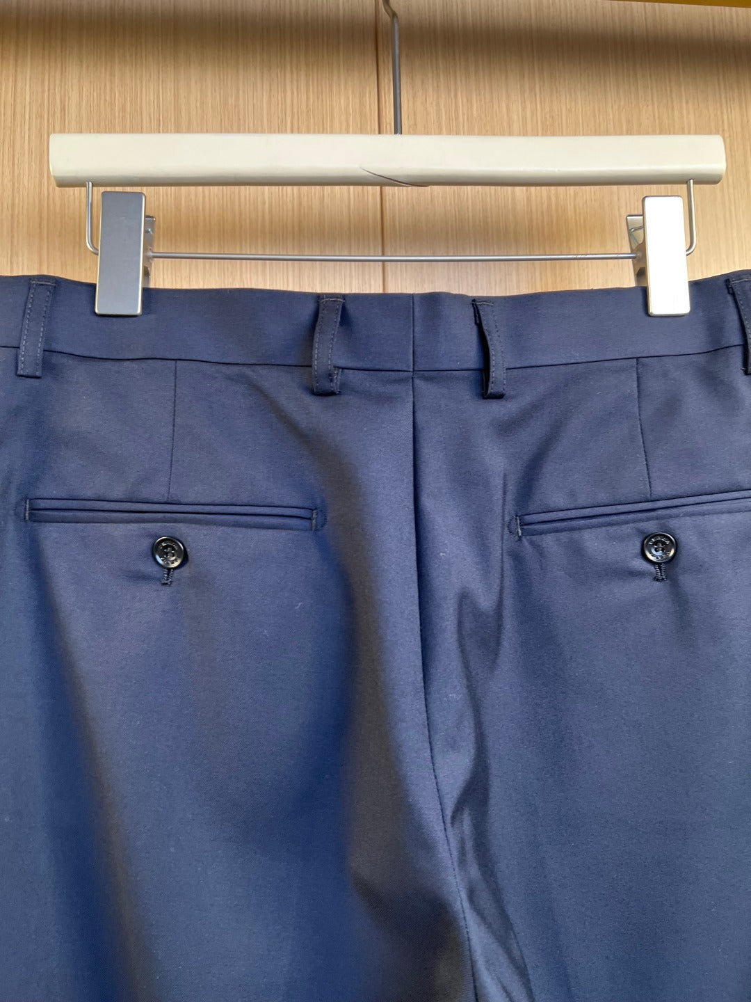 Navy pants front with two side pockets and button closure.