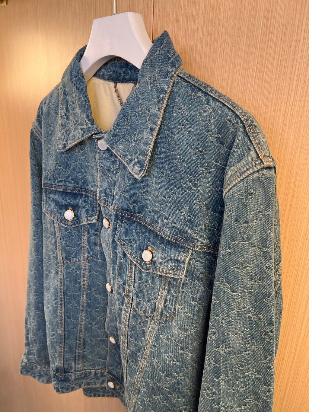 Denim jacket with flap chest pocket, pointed collar, and round metal buttons.