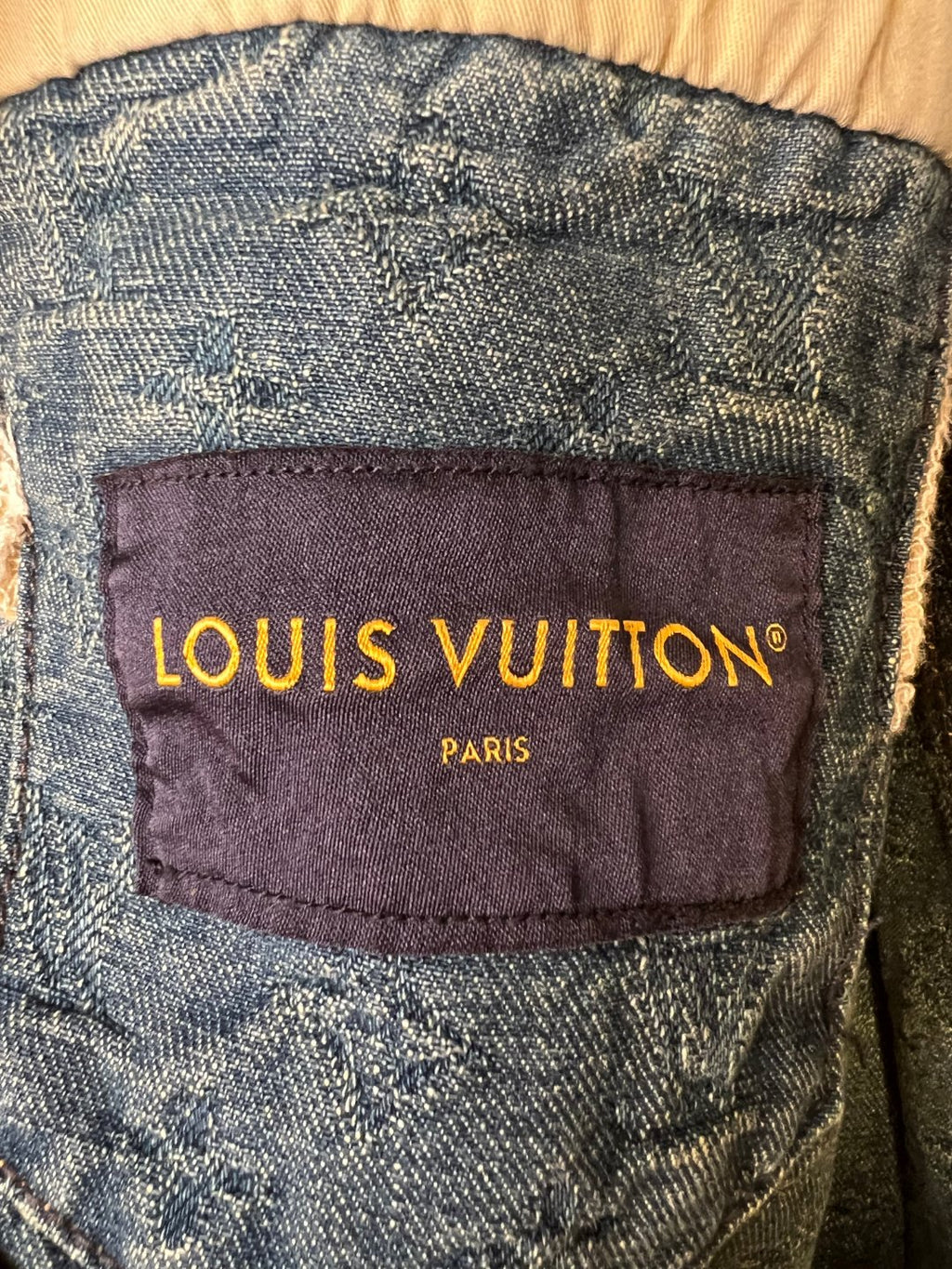 Interior fabric label with "LOUIS VUITTON" and "PARIS" text on denim.