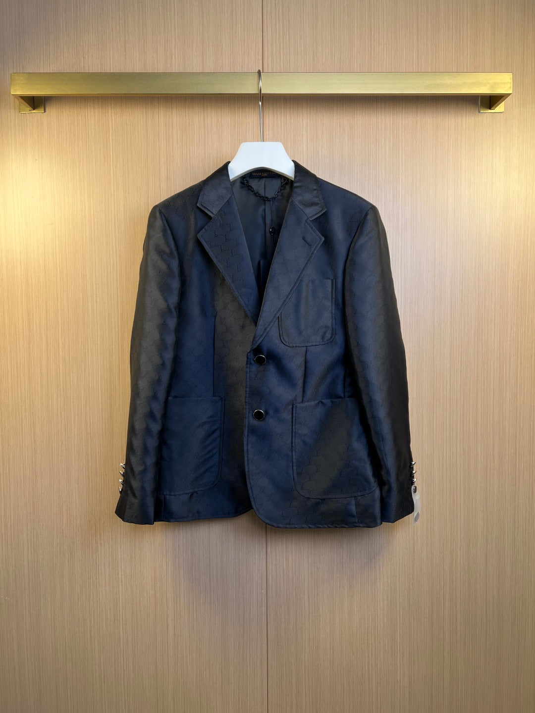 Dark navy blazer and trousers set on hangers, buttoned front and flap pockets