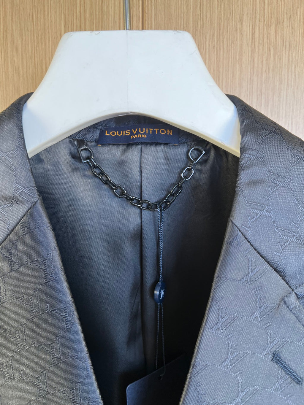 Louis Vuitton blazer hanger view, monogram-lined interior with chain detail