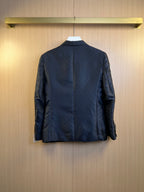 Dark navy blazer back view with center seam and lightly embossed monogram texture