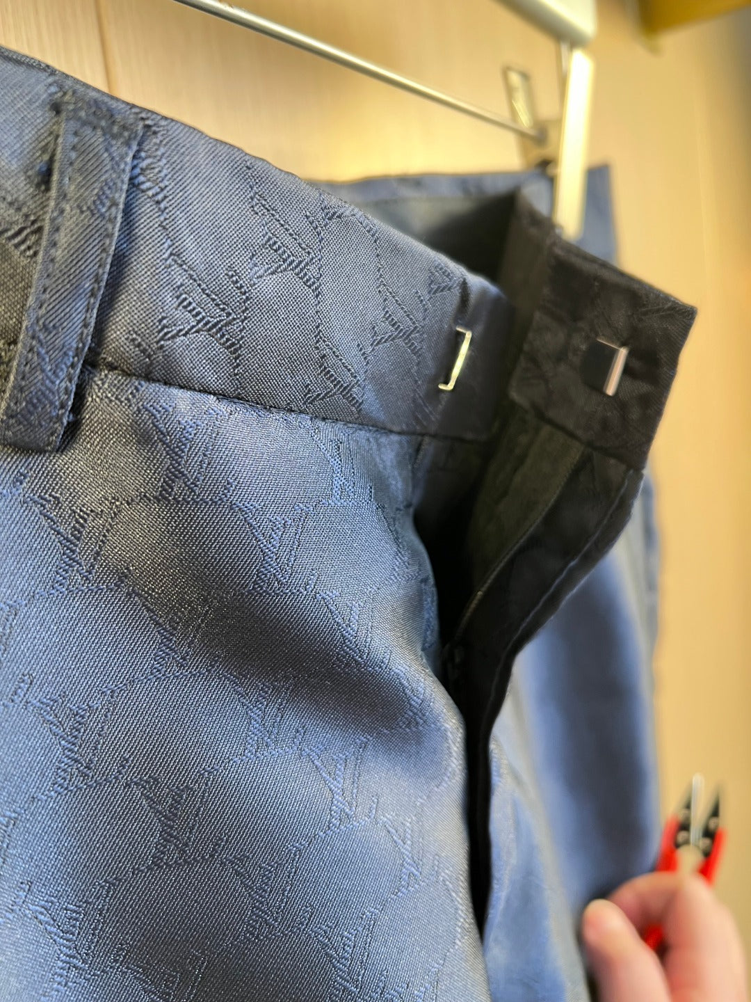 Louis Vuitton navy trouser pocket and belt loop, allover monogram pattern.