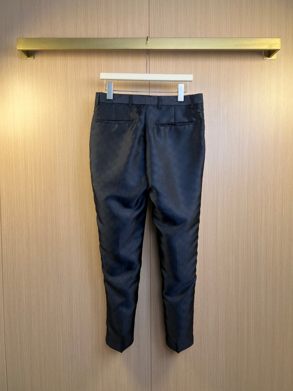 Louis Vuitton navy trousers with allover monogram pattern, full front view.