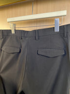 Dark pants with front welt pockets and belt loops, close-up on waistband