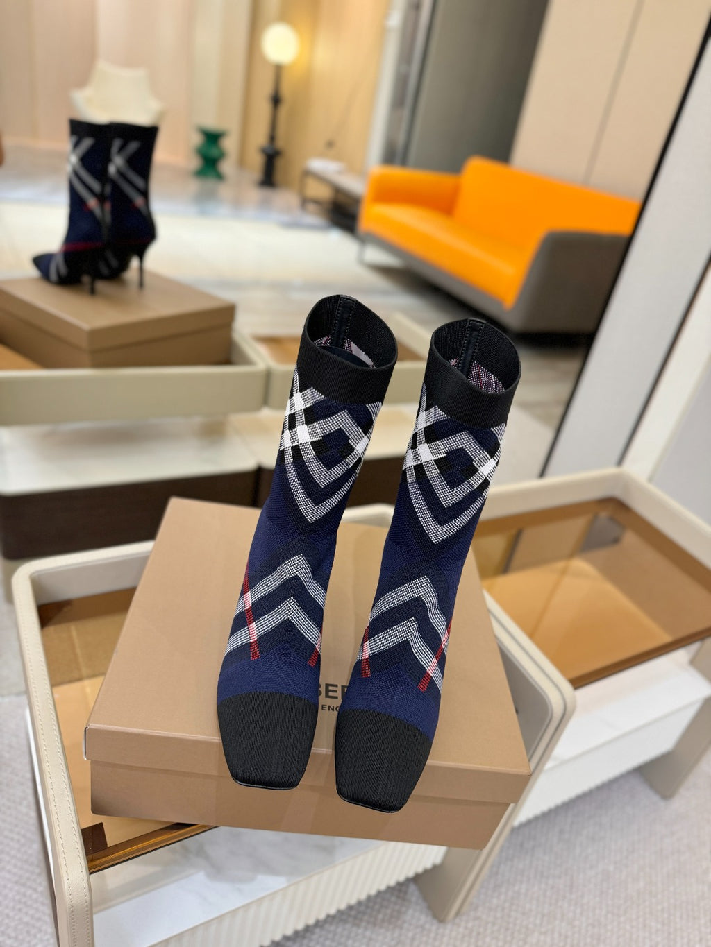 Pair of navy ankle boots with plaid trim and stiletto heels