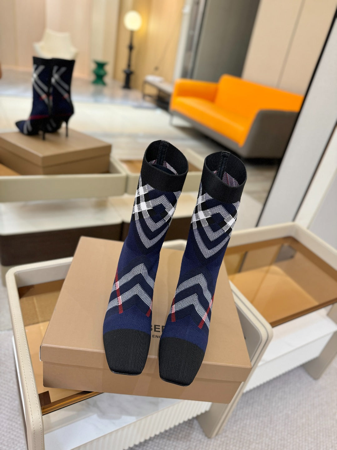 Pair of navy ankle boots with plaid trim and stiletto heels