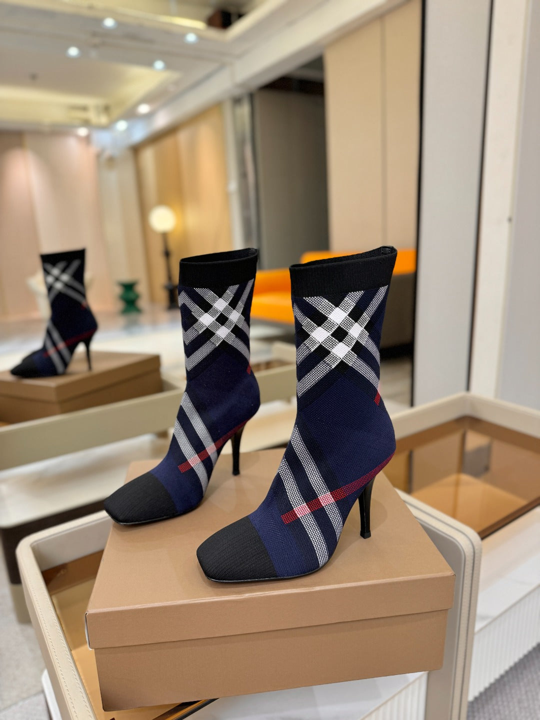 Navy ankle boots with plaid shaft and stiletto heel, angled side view