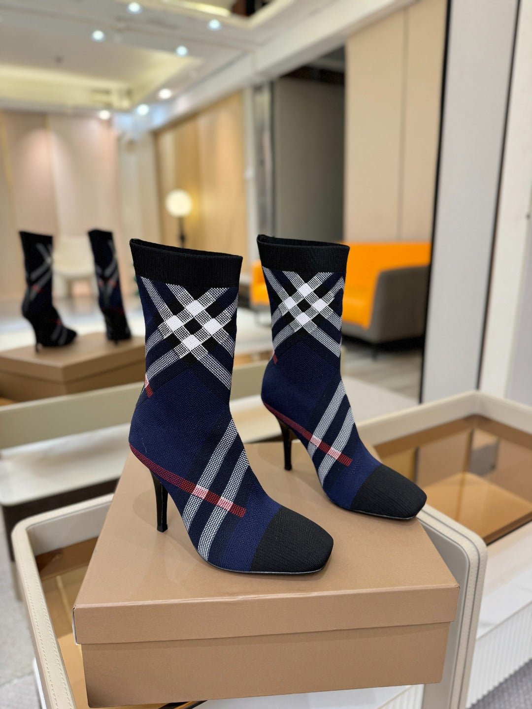 Navy ankle boots with black, white, and red plaid check and stiletto heel