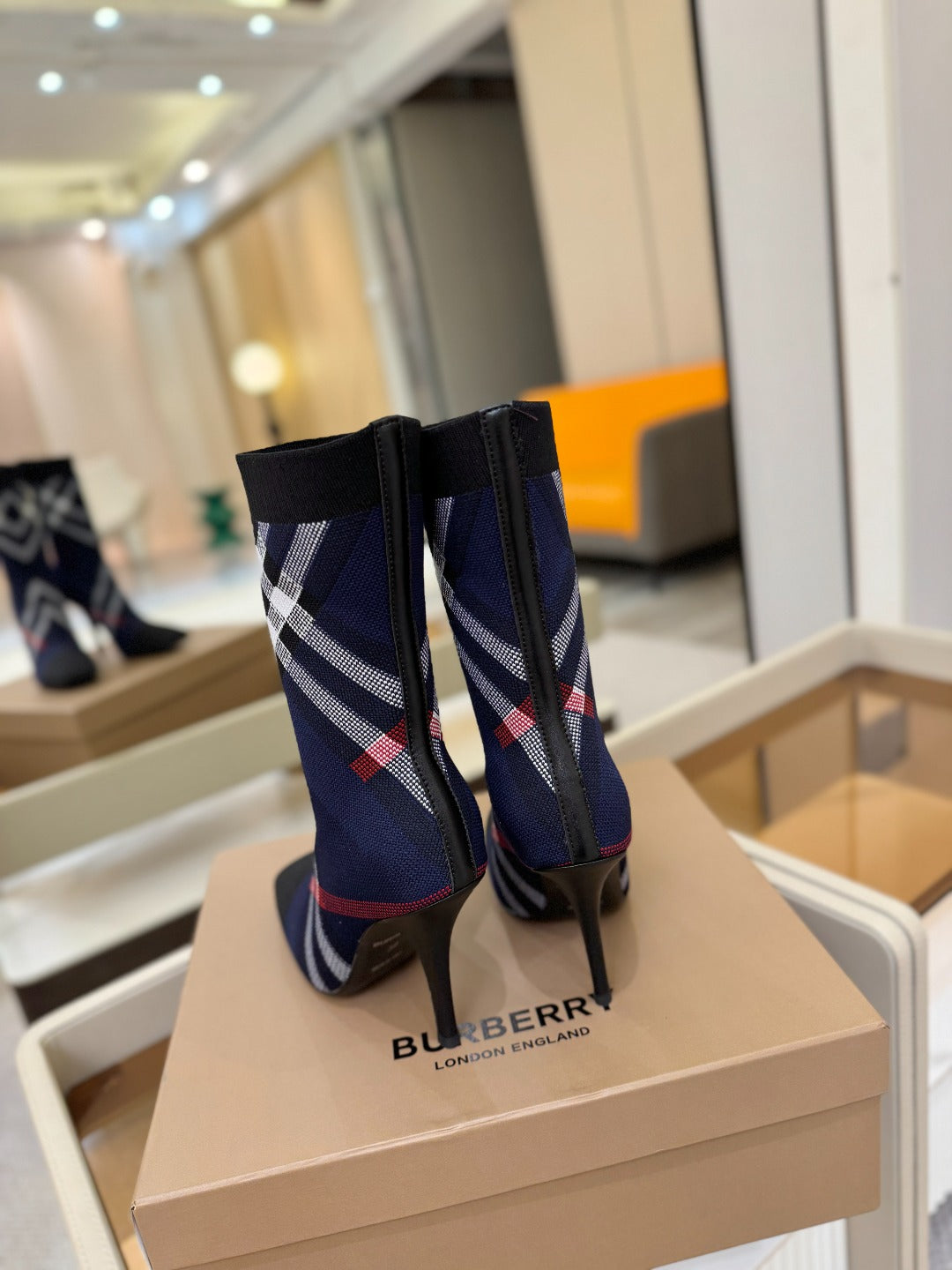 Navy ankle boots with side plaid stripe and stiletto heel, rear view