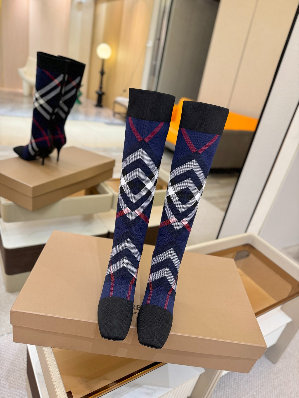 Knee-high knit boots with navy geometric check pattern and stiletto heels
