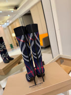 Back view of knee-high knit boots with navy, red, and white check pattern and stiletto heels