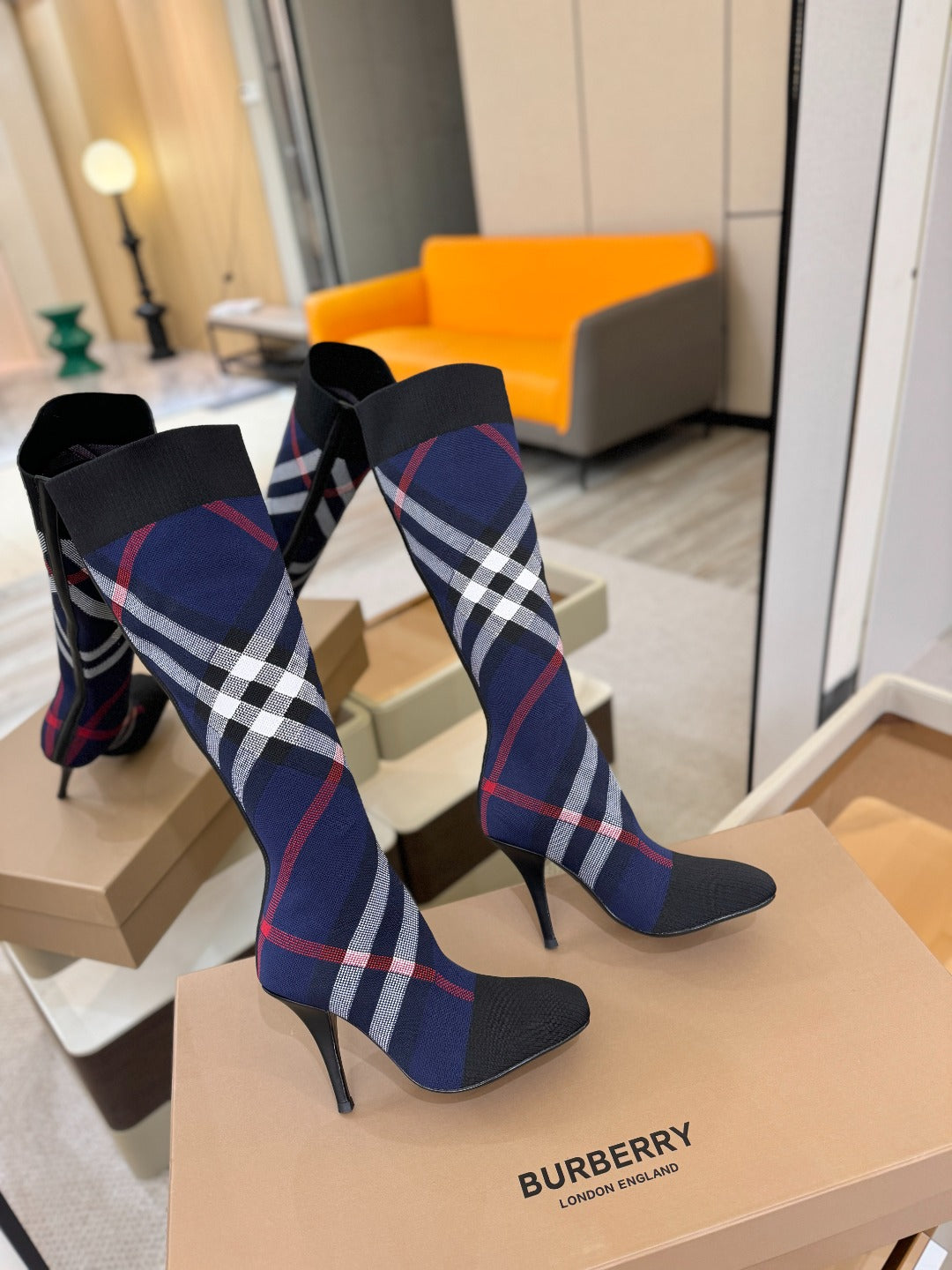 Knee-high knit boots with navy, red, and white check pattern and slender stiletto heels
