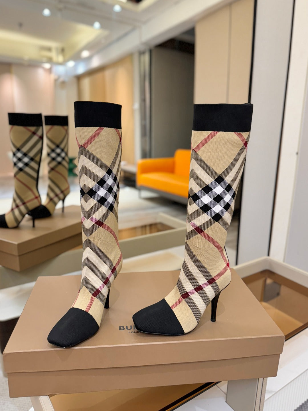 Tartan sock-style knee-high boots with black cuffs and plaid checks, stiletto heels