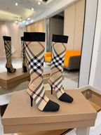Pair of tartan sock-style knee-high boots with black cuffs and check panels, stiletto heels
