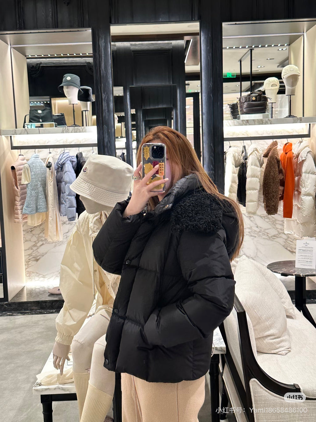 Black long puffer jacket with faux-fur hood, front zipper, hooded back view