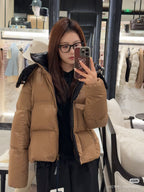 Tan long puffer jacket with faux-fur hood and front zipper, side profile view
