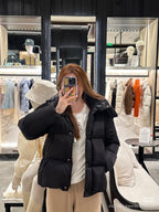 Black long puffer jacket with faux-fur hood, front zipper and stand-up collar